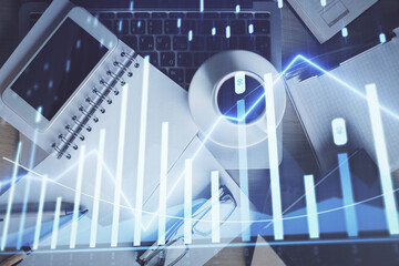 Double exposure of financial graph hologram over desktop with phone. Top view. Mobile trade platform concept.