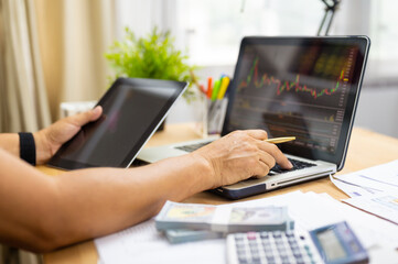 Fototapeta premium Man analyzing stock exchange or forex graph on laptop at home concept of investment and freelancer