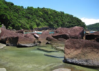 Rocks and blue water in a brazilian paradise beach - Praia das Conchas - Ubatuba - SP