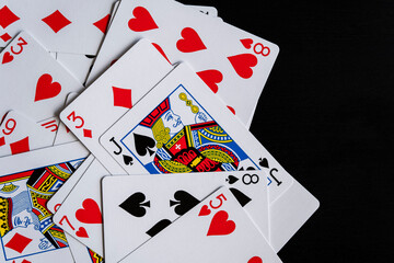 Mixed playing cards on a black table