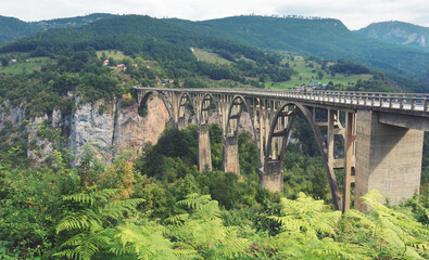 Fototapeta na wymiar Djurdzhevich Bridge. Montenegro. Reinforced concrete arch bridge over the Tara river