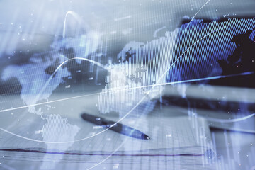 Double exposure of financial graph drawings and desk with open notebook background. Concept of forex market