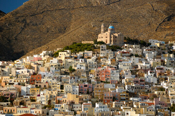 Budynki Greckiej wyspy Siros widziana od strony morza w pogodny dzień