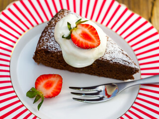 Homemade chocolate cake with whipped cream and strawberries