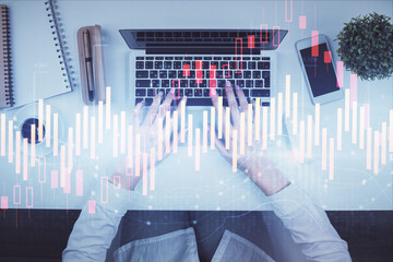 Double exposure of woman hands working on computer and forex chart hologram drawing. Top View. Financial analysis concept.