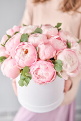 Round box with Bouquet of Pink peonies in a women hand. Beautiful peony flower for catalog or online store. Floral shop concept . Beautiful fresh cut bouquet. Flowers delivery