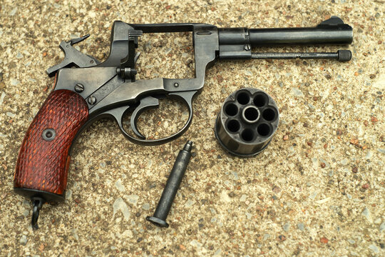 The pistol of the Nagant system is disassembled on the concrete floor