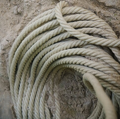 skein of rope on white sand background. empty copy space for inscription.