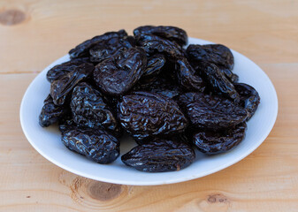 Tasty dried plums on wooden background close up