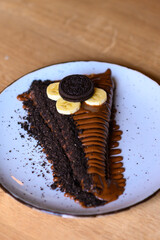 a beautifully decorated caloric pancake full of chocolate.
pancake on a blue plate with many different chocolate toppings.