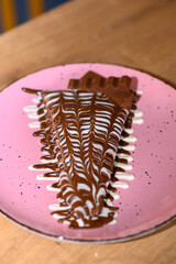 
a beautifully decorated caloric pancake full of delicious chocolate.
pancake on a different plate with many different chocolate toppings.
a calorie bomb called love
