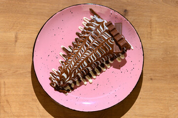 
a beautifully decorated caloric pancake full of delicious chocolate.
pancake on a different plate with many different chocolate toppings.
a calorie bomb called love