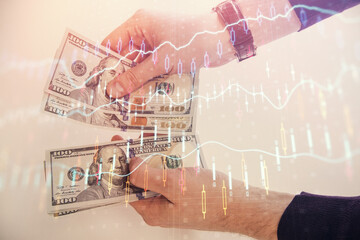 Multi exposure of financial graph drawing hologram and USA dollars bills and man hands. Analysis concept.