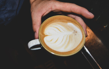Man holding cappuchino cup in the hand. High quality photo