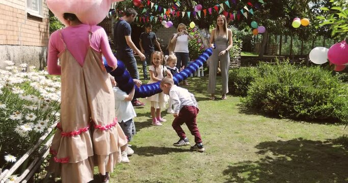Family celebrates a birthday outdoors. Small children have fun with the animators and parents.
