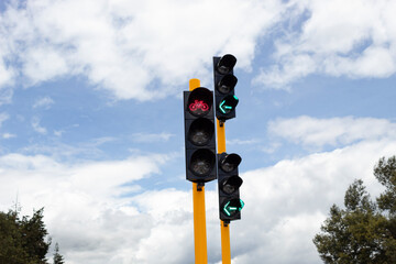 Closeup to a couple of traffic lights with blue sky at background 