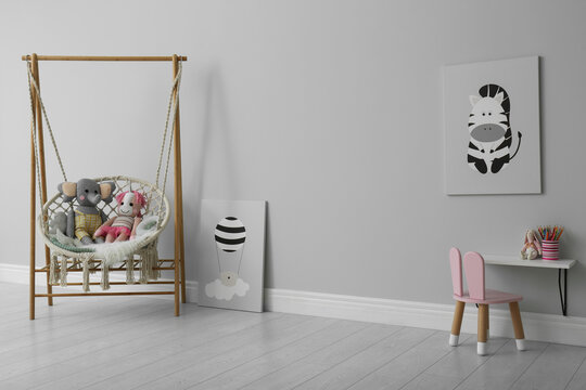 Stylish child's room interior with adorable paintings and hanging chair