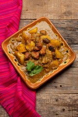 Mexican longaniza with green sauce and potatoes on wooden background