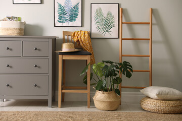 Stylish room interior with decorative ladder and monstera plant