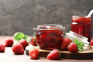 Delicious pickled strawberry jam and fresh berries on wooden table