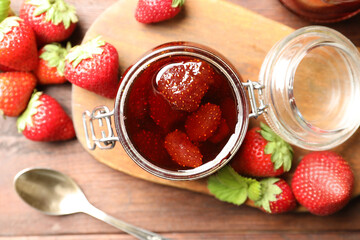 Delicious pickled strawberry jam and fresh berries on wooden table, flat lay