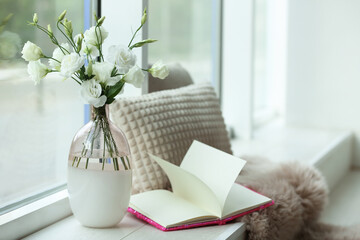 Stylish vase with fresh flowers and book on window sill - Powered by Adobe