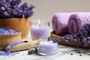Obraz na płótnie Canvas Cosmetic products and lavender flowers on white marble table