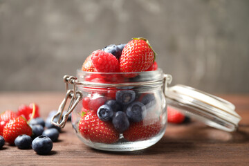 Mix of ripe berries on wooden table