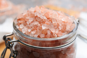 Fototapeta na wymiar Pink himalayan salt in glass jar, closeup