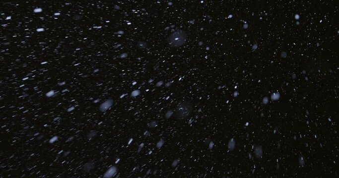 Low angle view of snow falling at night, Maine, USA