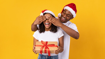 Husband Congratulating Wife On Christmas, Covering Her Eyes, Yellow Background