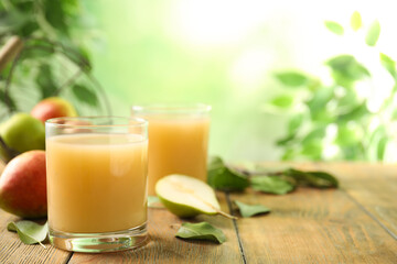 Fresh pear juice in glass on wooden table, closeup. Space for text