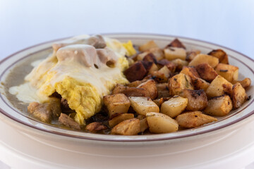 Generous serving meal of a hearty chili verde covered in green sauce combined with eggs and potatoes.
