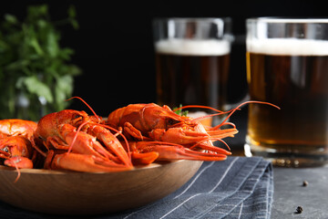 Delicious red boiled crayfishes on table against black background, closeup