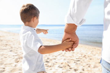 Little boy with grandfather on sea beach, closeup