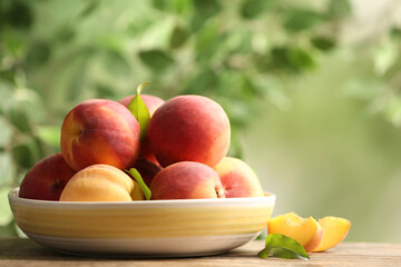 Fresh sweet peaches on wooden table outdoors