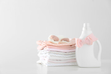 Fototapeta na wymiar Detergent and children's clothes on white table