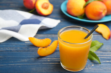 Natural peach juice and fresh fruits on blue wooden table