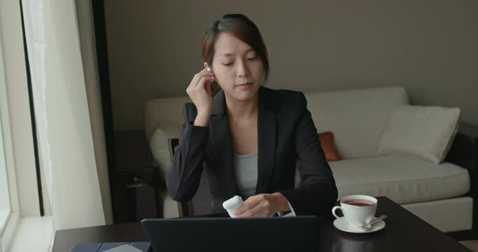Businesswoman talk to earphone with meeting on laptop