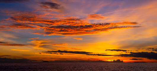 Panorama Beautiful colorful sunset at the sea with dramatic clouds and sun shining.