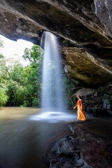 Woman standing in Saeng Chan Waterfall at Pha Taem National Park, Ubon Ratchathani, Thailand.