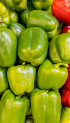 Fototapeta na wymiar Green bell peppers in a pile ready for sale.