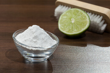 Baking soda - sodium bicarbonate and lemon on the wooden dark.