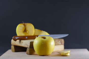 Fresh yellow apple in front of other freshly cut apples