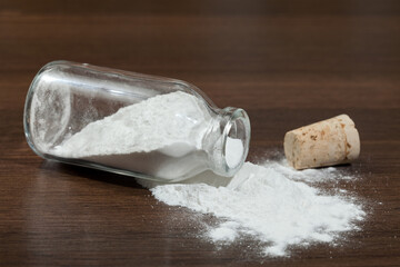 Baking soda - sodium bicarbonate in a glass jar on dark wooden background.