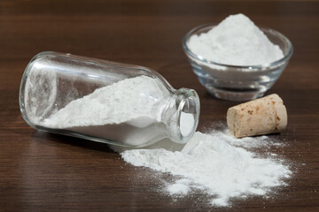 Baking soda - sodium bicarbonate in a glass jar on dark wooden background.