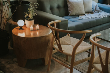 wooden table with lamp, candles and a sofa