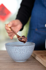 The Chinese in the traditional festival Laba Festival prepare to scoop the boiled Laba congee into a bowl