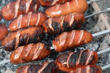 close-up of roasted sausages on barbecue grill. BBQ party in garden