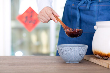 The Chinese in the traditional festival Laba Festival prepare to scoop the boiled Laba congee into a bowl